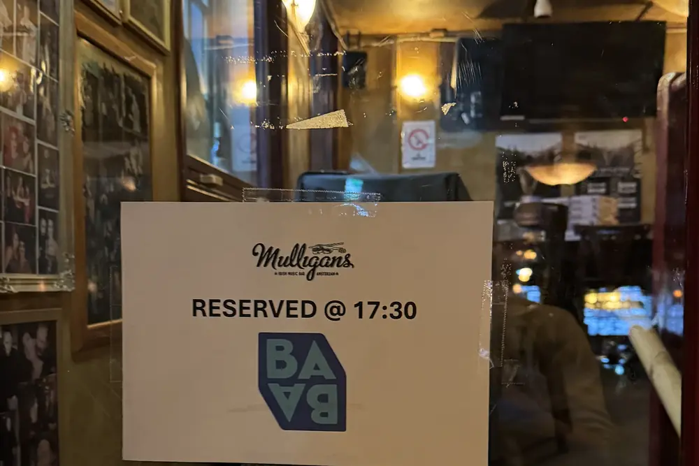 A card at the top of the stairs in Mulligans reading Reserved at 17:30, with the Salon mark on it.